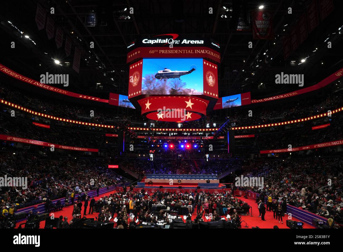 Attendees watch at an Inauguration parade as a screen shows former