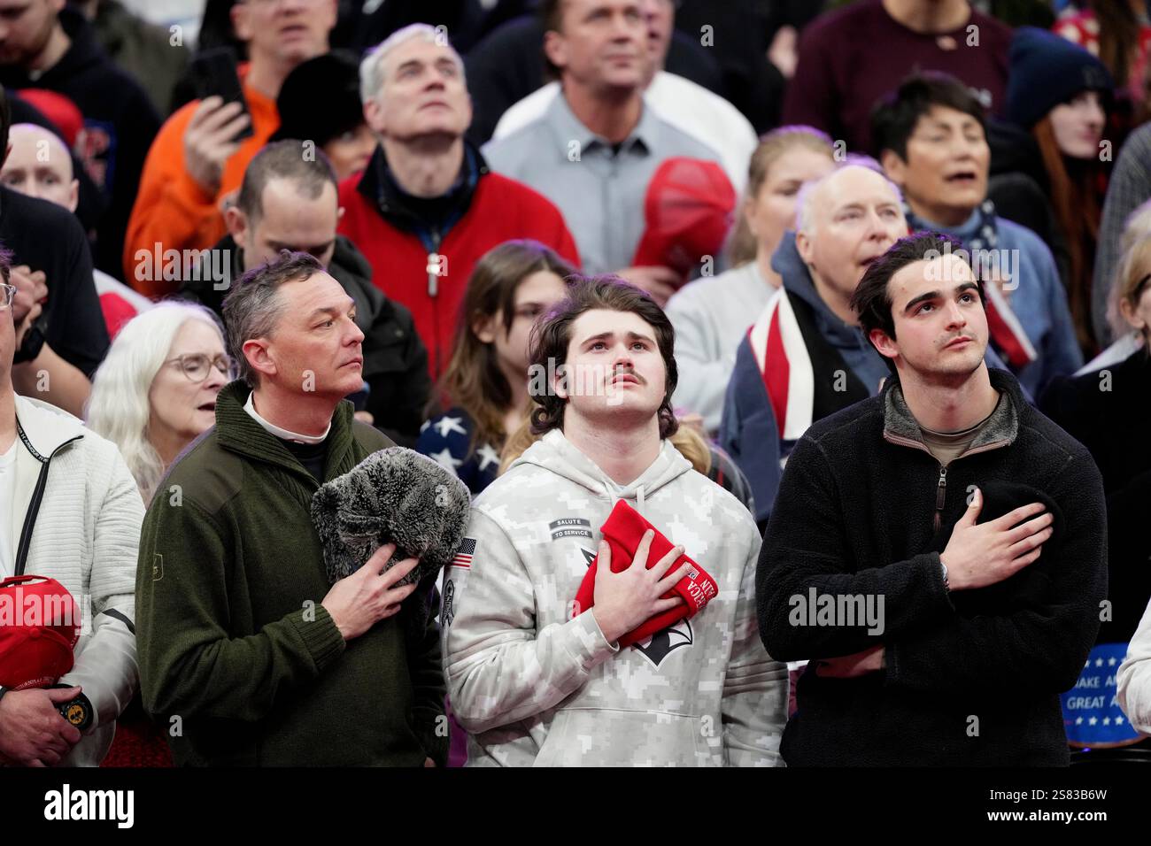 Singing Inaugration Attendees watch during the singing of the national anthem at an indoor ...