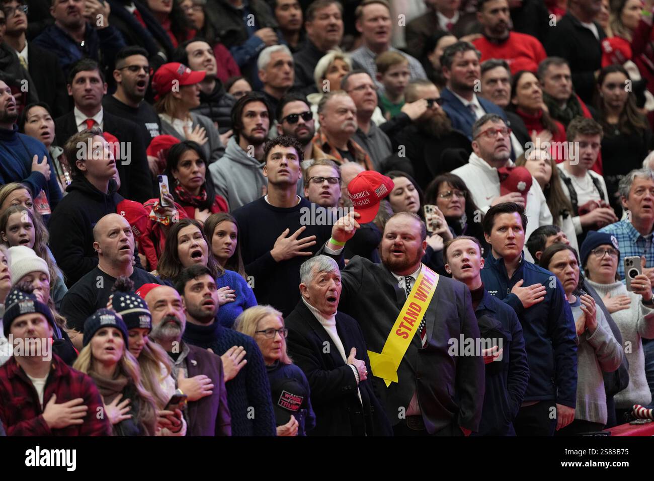 Singing Inaugration Attendees watch during the singing of the national anthem at an indoor ...