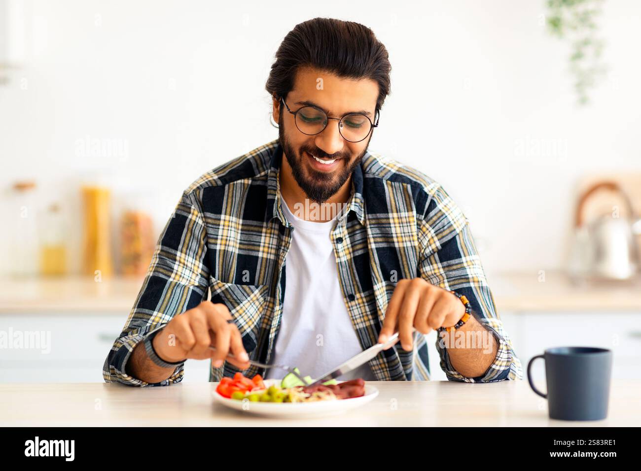 Positive arab guy having healthy breakfast at home Stock Photo