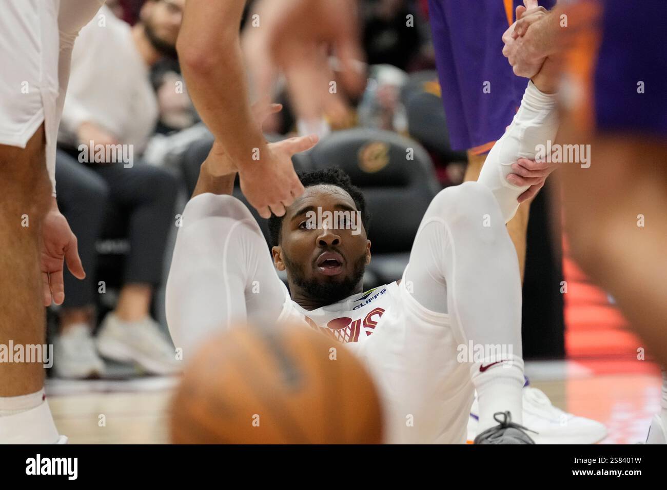 Cleveland Cavaliers guard Donovan Mitchell is helped up by teammates