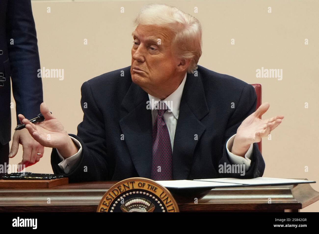 President Donald Trump gestures as he signs executive orders at an