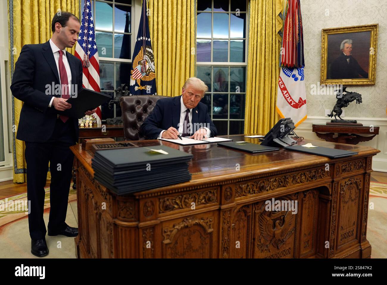 President Donald Trump signs an executive order withdrawing the U.S