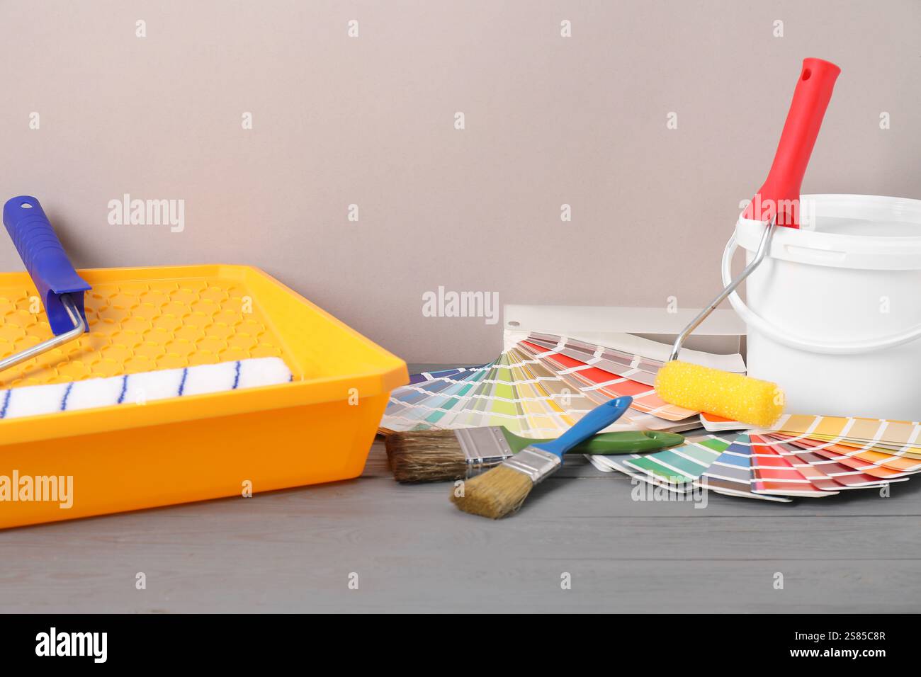 Different painter's tools on grey wooden table. Decorating and design Stock Photo