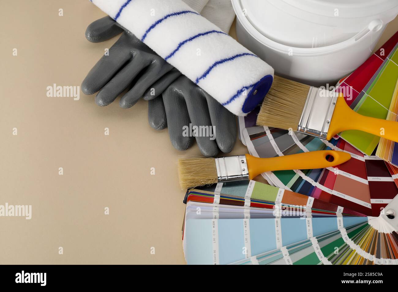 Different painter's tools on beige table, space for text. Decorating and design Stock Photo