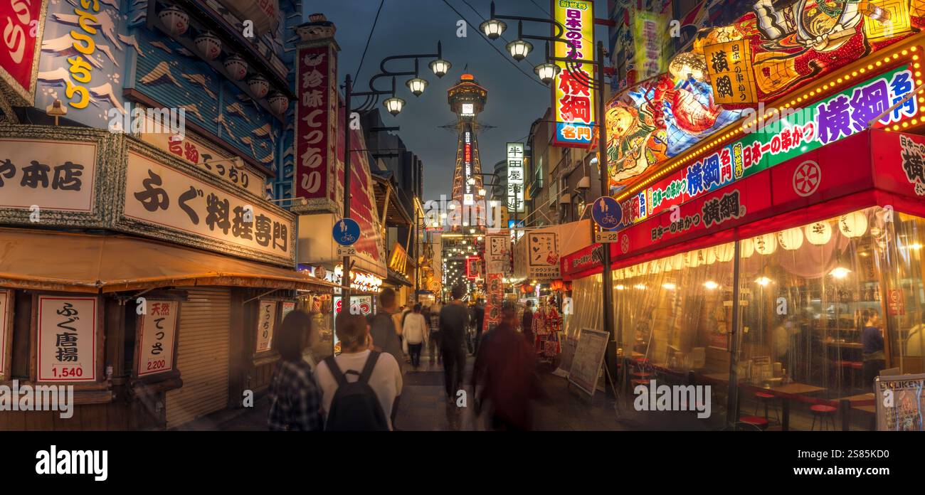 View of Tsutenkaku Tower and restaurants neon lights at night in the Shinsekai area, Osaka, Honshu, Japan Stock Photo