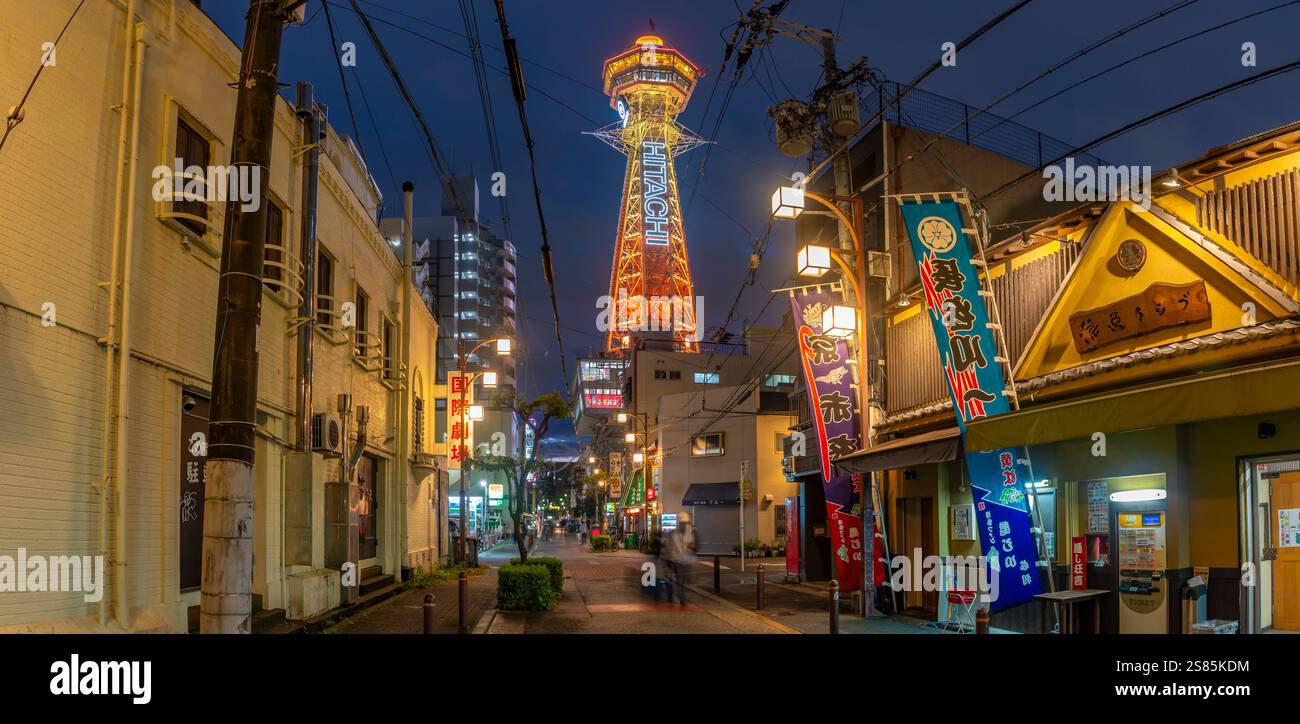 View of Tsutenkaku Tower and restaurants neon lights at dusk in the Shinsekai area, Osaka, Honshu, Japan Stock Photo