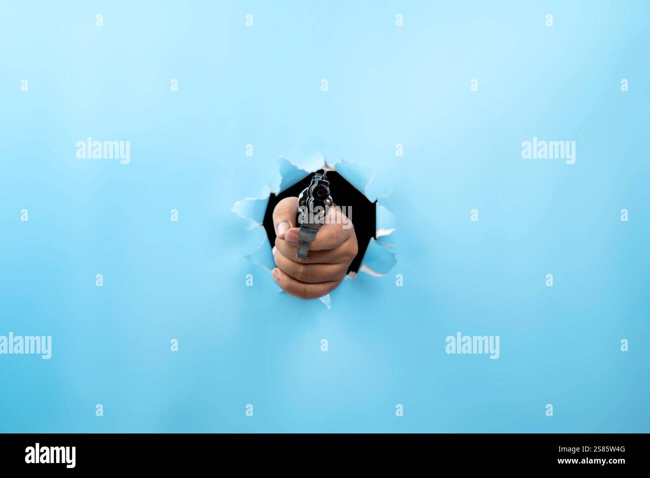 Human hand holding handgun through ripped paper. Hand gestures. Mockup ...