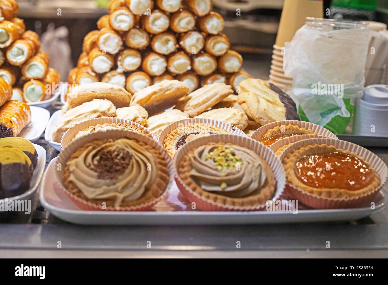 tartlets with cream and chocolate, caramel and jam on the display case. Italian desserts, Traveling around Europe Stock Photo