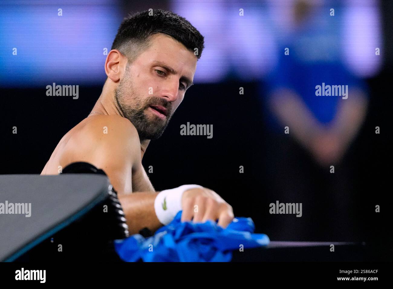 Novak Djokovic of Serbia changes his shirt during his quarterfinal