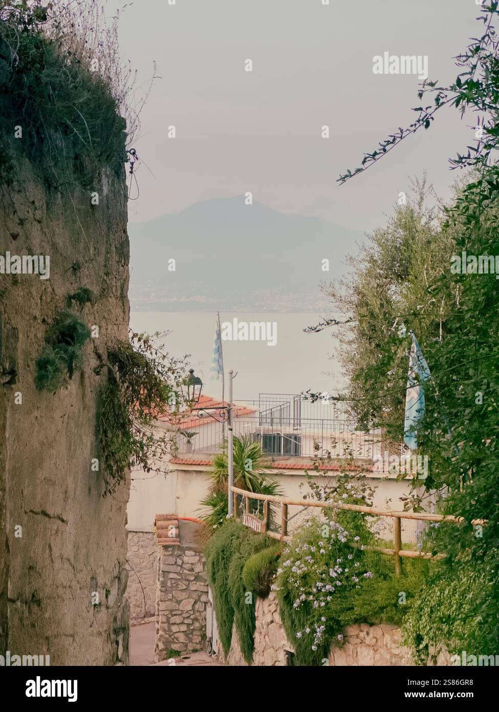 A tranquil view from a quiet side street in Vico Equense, where the peaceful charm of the town meets the distant majesty of Mount Vesuvius. - Smartphone Captured Stock Image