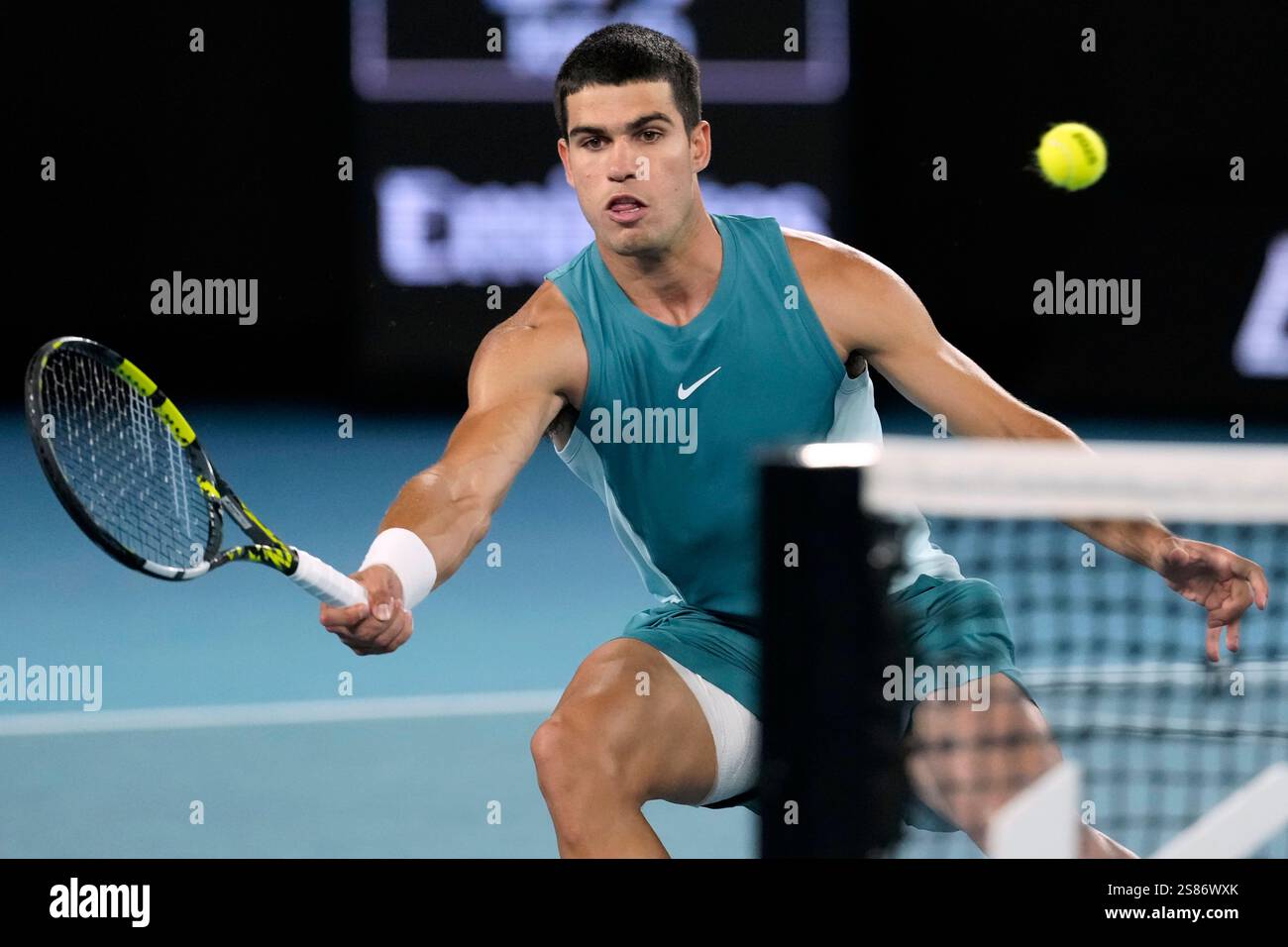 Carlos Alcaraz of Spain plays a forehand return to Novak Djokovic of