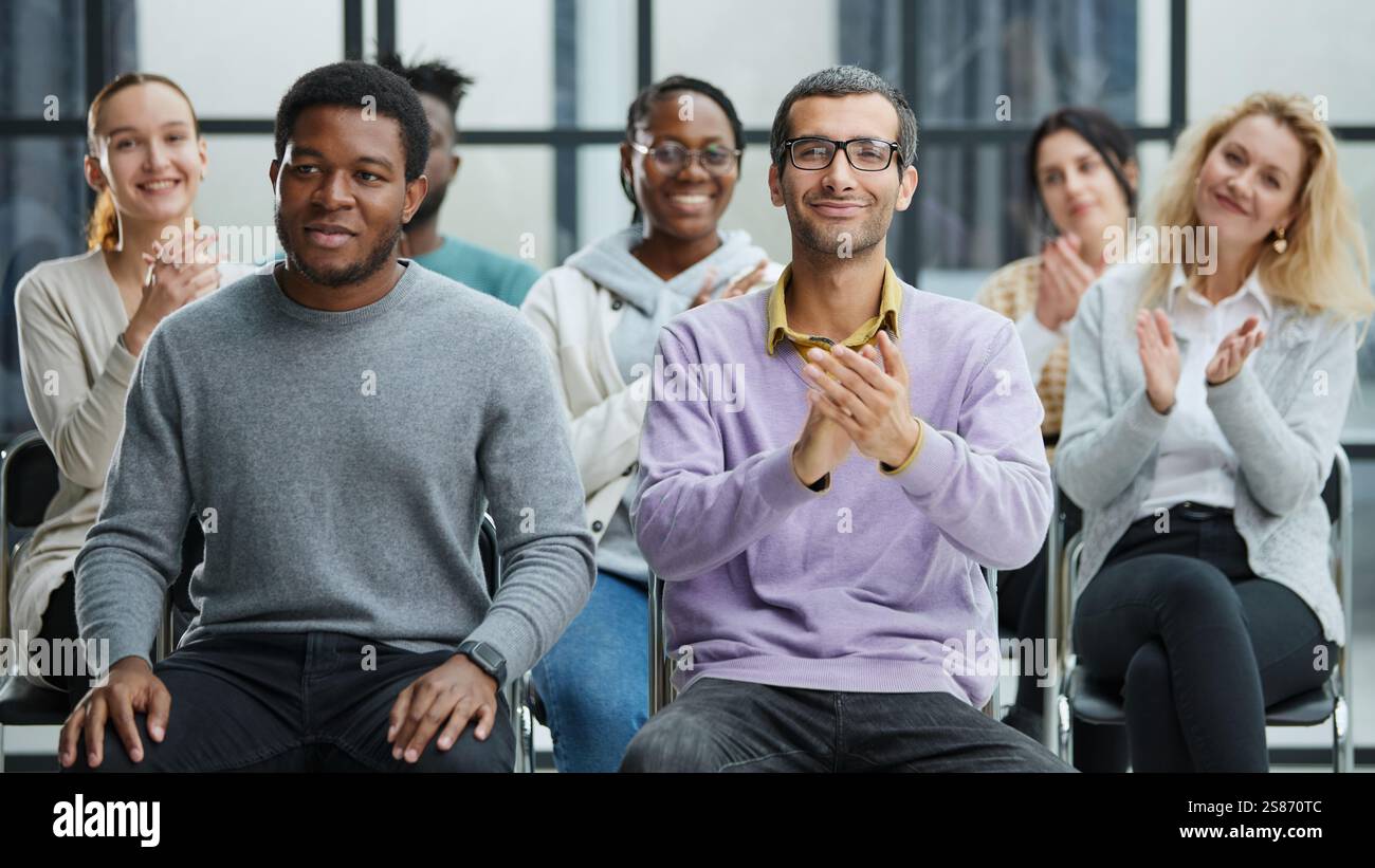 Happy multiethnic employees having fun while discussing project, sharing ideas, informal brainstorming sitting on chairs Stock Photo