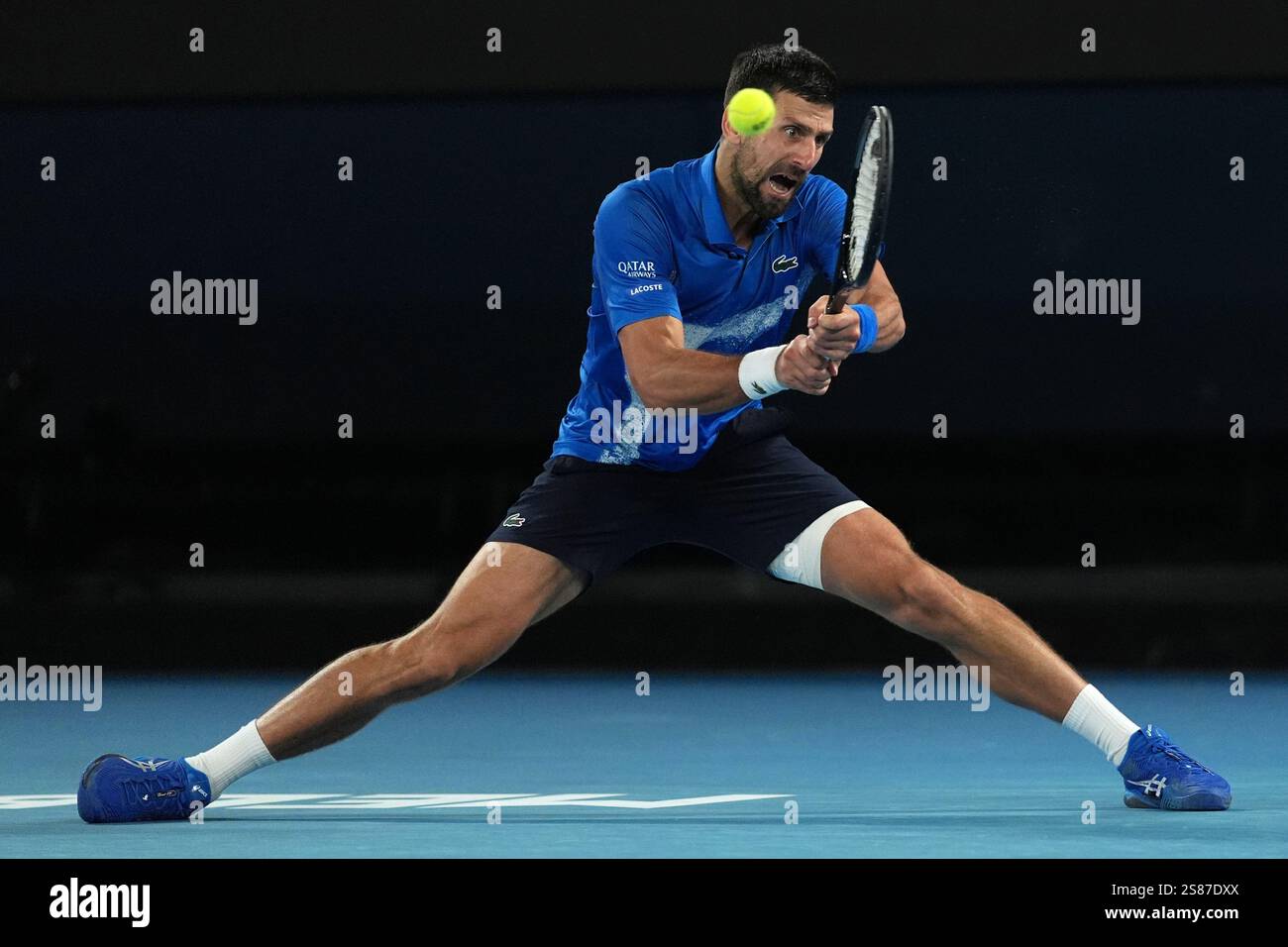 Novak Djokovic of Serbia plays a backhand return to Carlos Alcaraz of Spain during their quarterfinal match at the Australian Open tennis championship in Melbourne, Australia, Wednesday, Jan. 22, 2025. (AP Photo/Ng Han Guan) Stock Photo