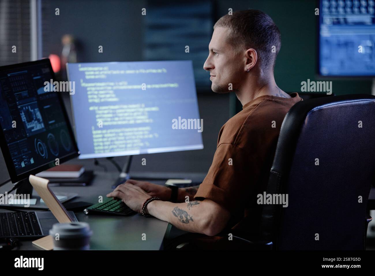 Side view of handsome male IT programmer typing on computer keyboard at ...