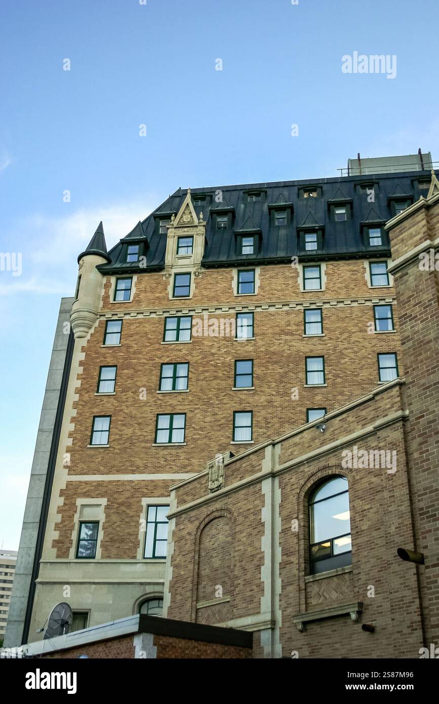 A large brick building with a black roof and a large window. The ...