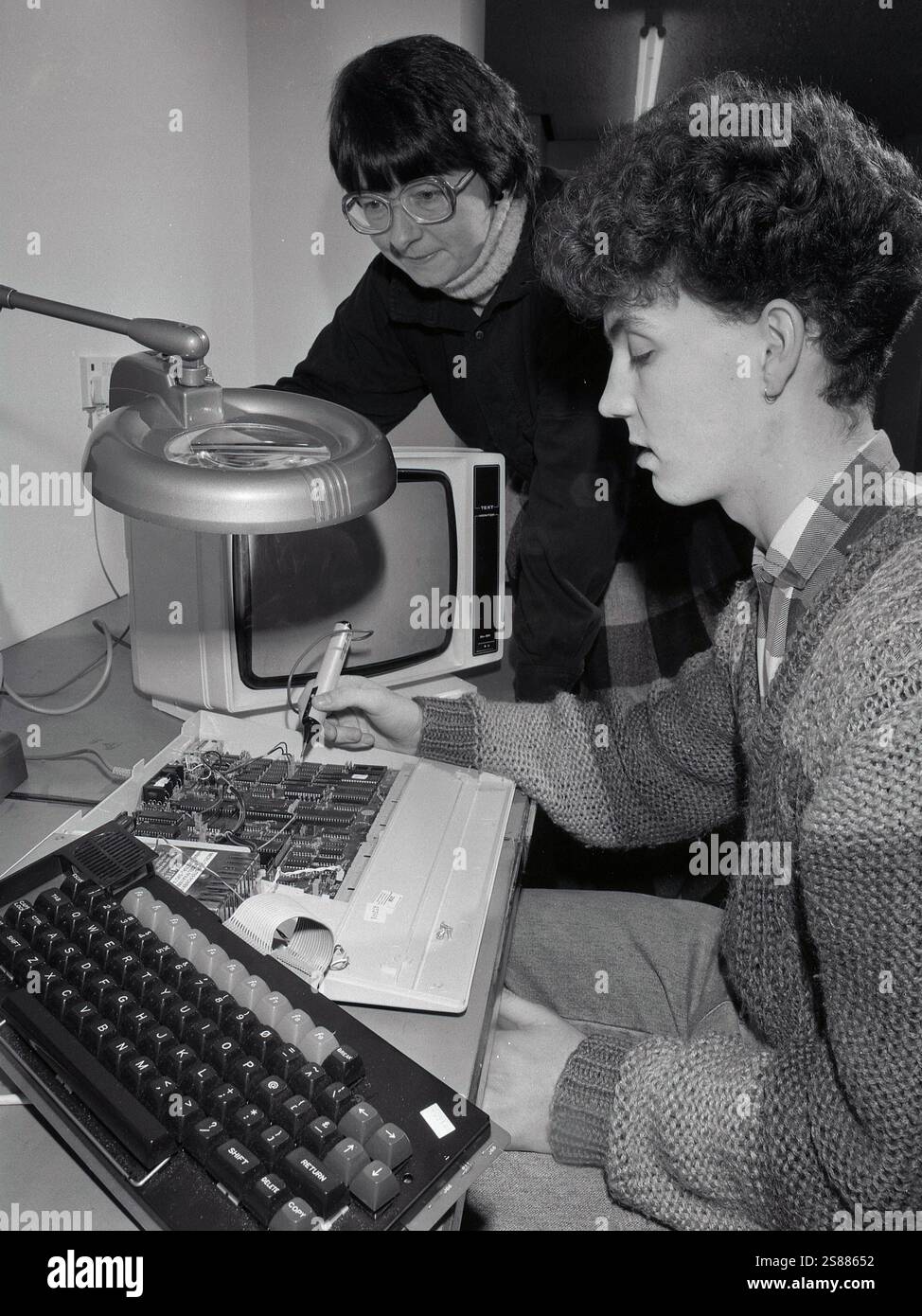 1985, a teenage boy working on the circuitboard of a micro computer ...