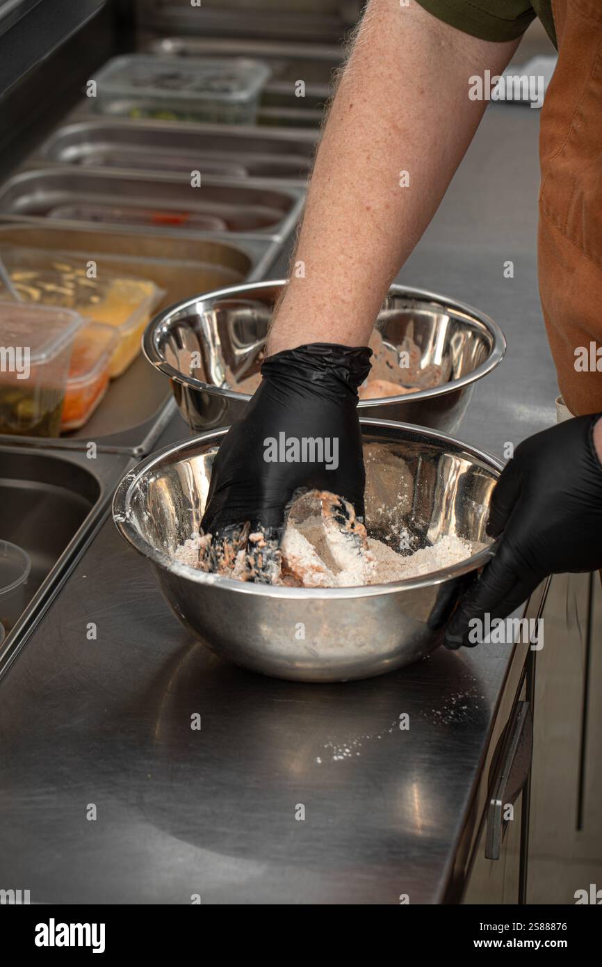 Chef breading chicken wings before frying Stock Photo