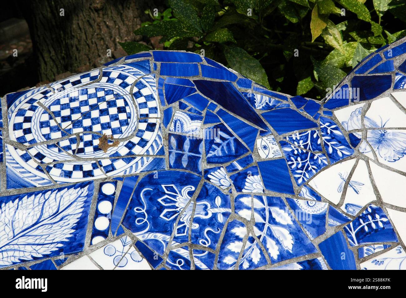 A butterfly and another insect fly amid foliage and flowers: detail of ...