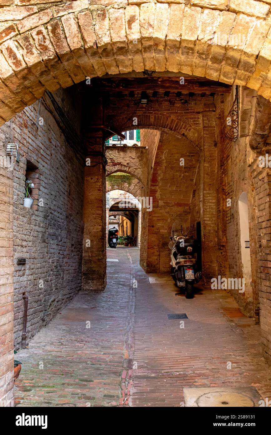 Narrow backstreet with archways in Siena,Italy Stock Photo