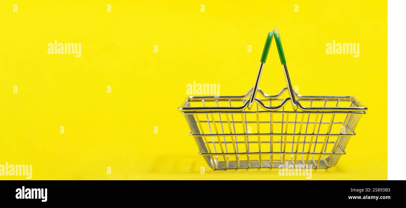 Empty shopping basket isolated on yellow background. Copy space for text Stock Photo