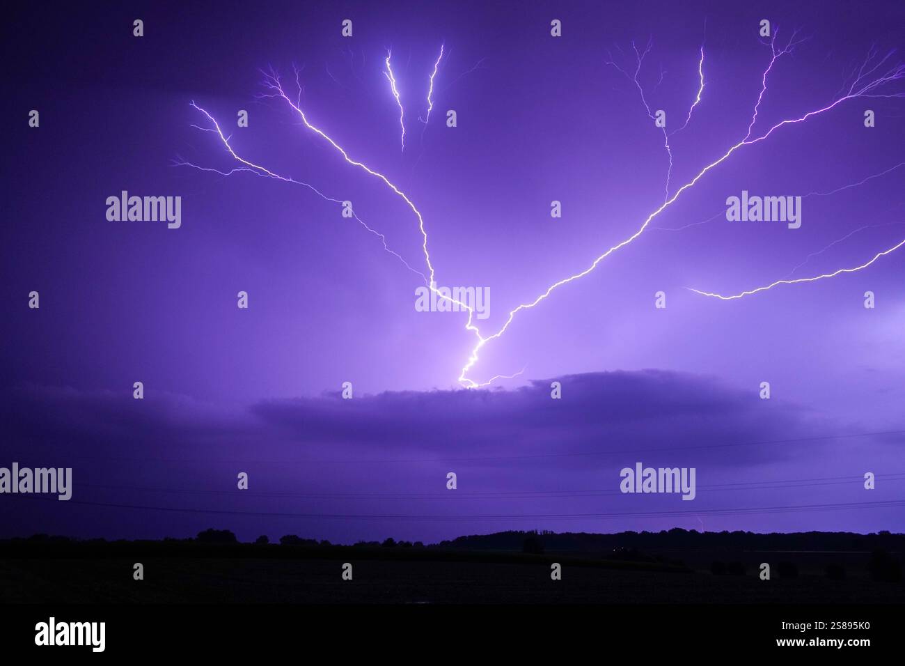 A purple sky with a lightning bolt in the middle. The sky is dark and ...