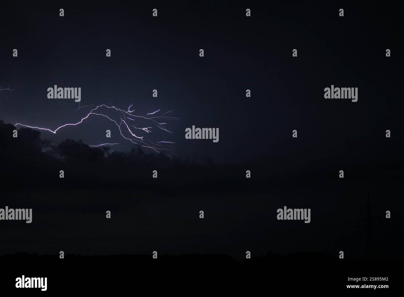 A dark sky with a lightning bolt in the middle. The sky is cloudy and ...