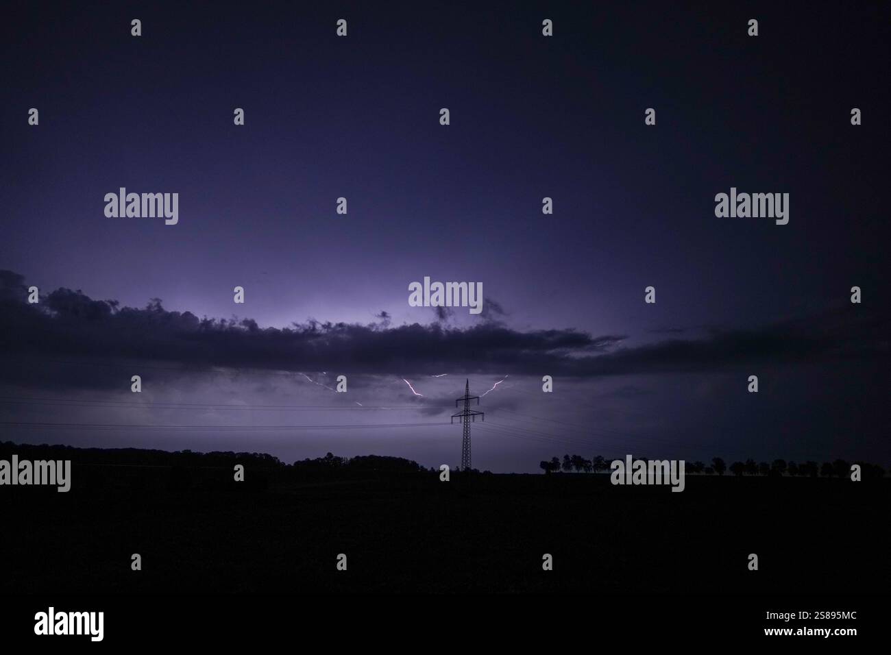 A dark sky with a lightning bolt in the middle. The sky is cloudy and ...