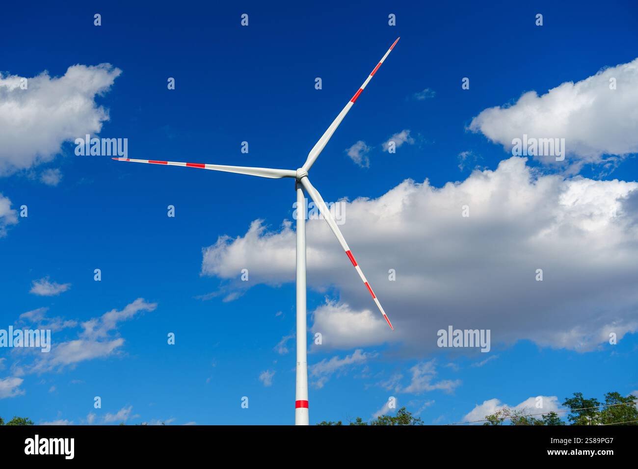 Wind turbine generating clean renewable energy on a blue sky background ...