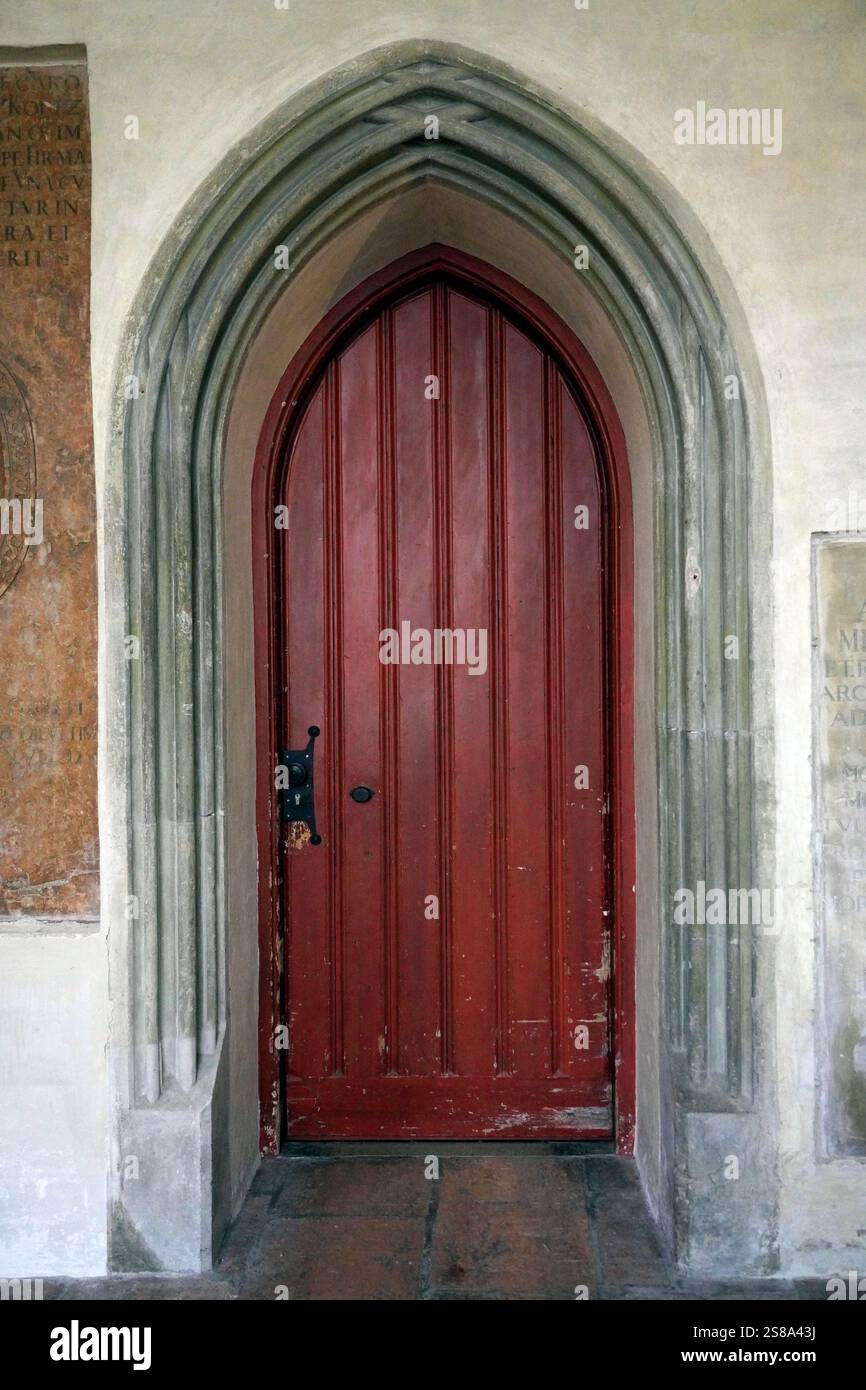 Arched red door set in a medieval church in southern Germany Stock Photo