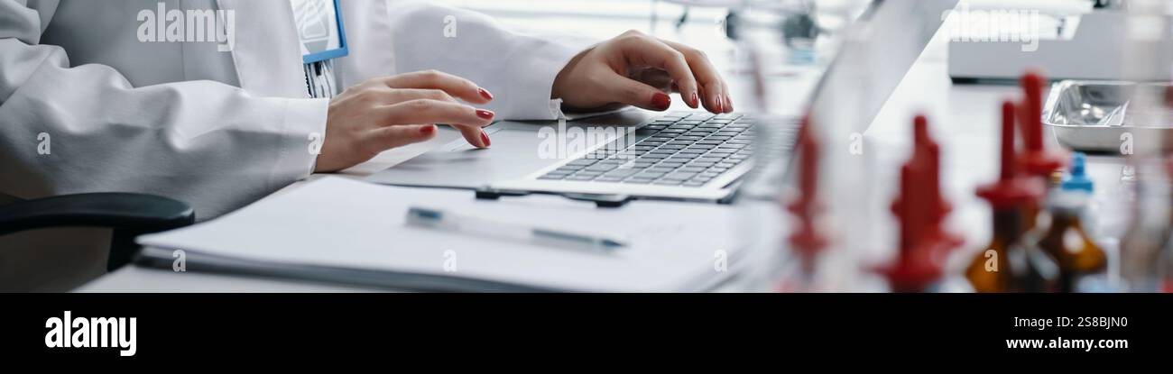 Typing on Laptop While Working in Laboratory Environment Stock Photo