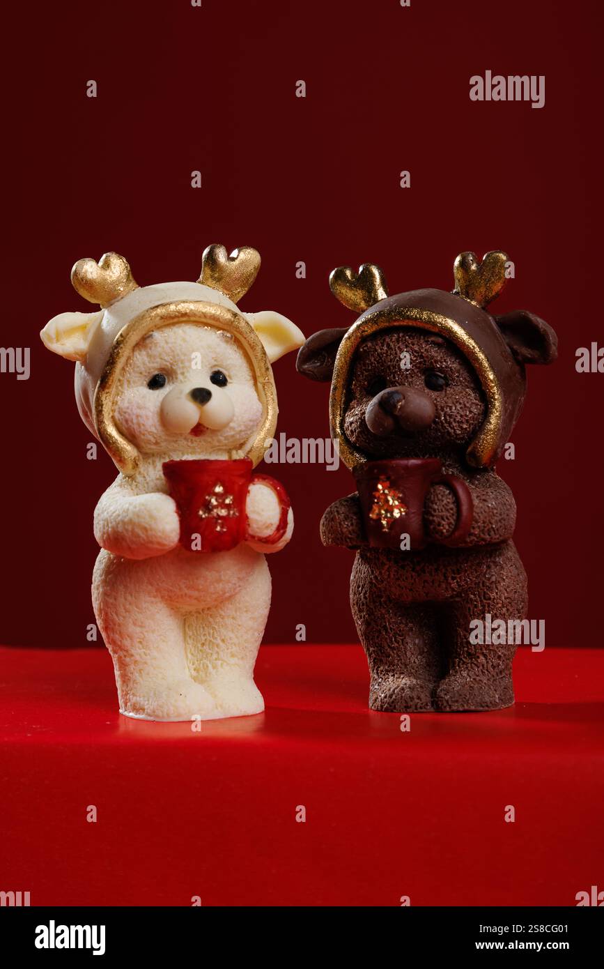 Two Christmas teddy bear figurines on a red background Stock Photo