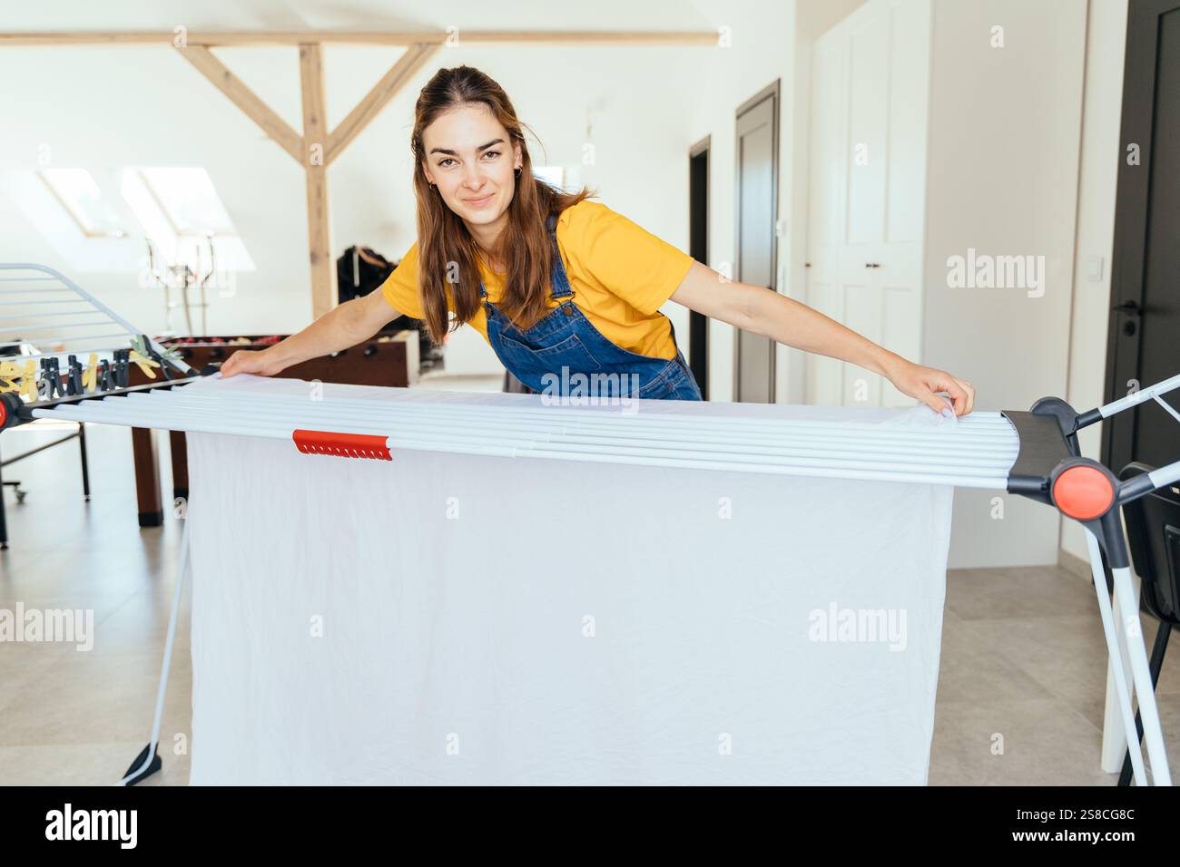 Wide angle portrait of hispanic brunette woman hanging clean laundry ...