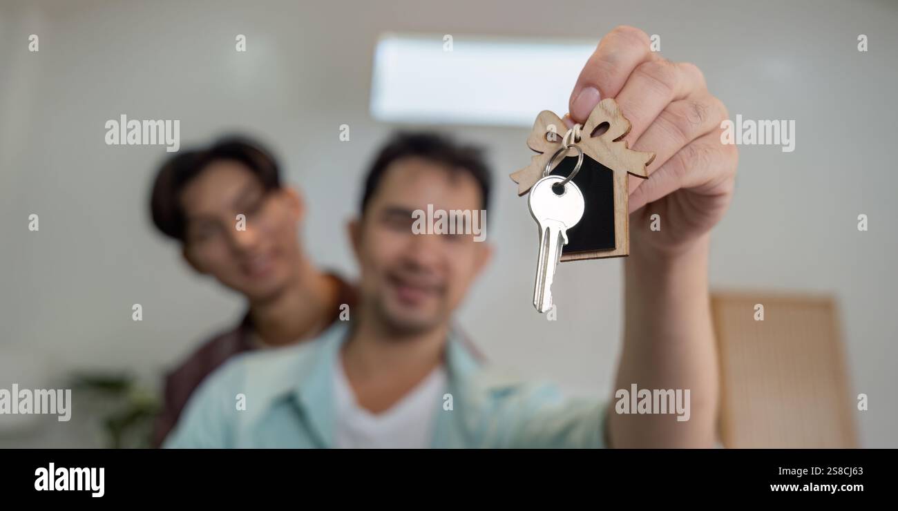 Gay couple proudly holding keys to their new home, celebrating their ...