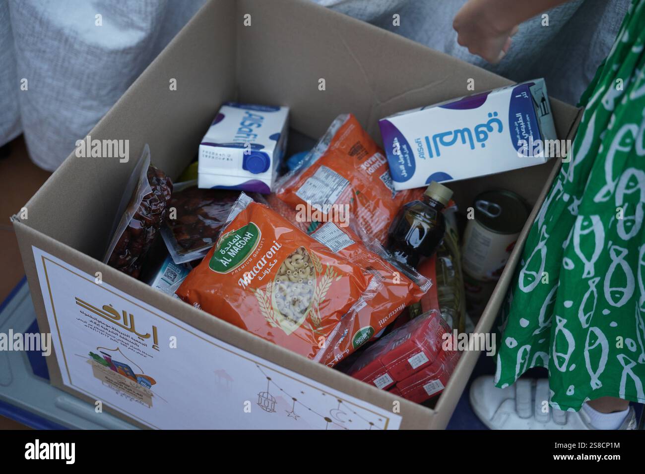 A food donation box containing essential items such as milk cartons ...