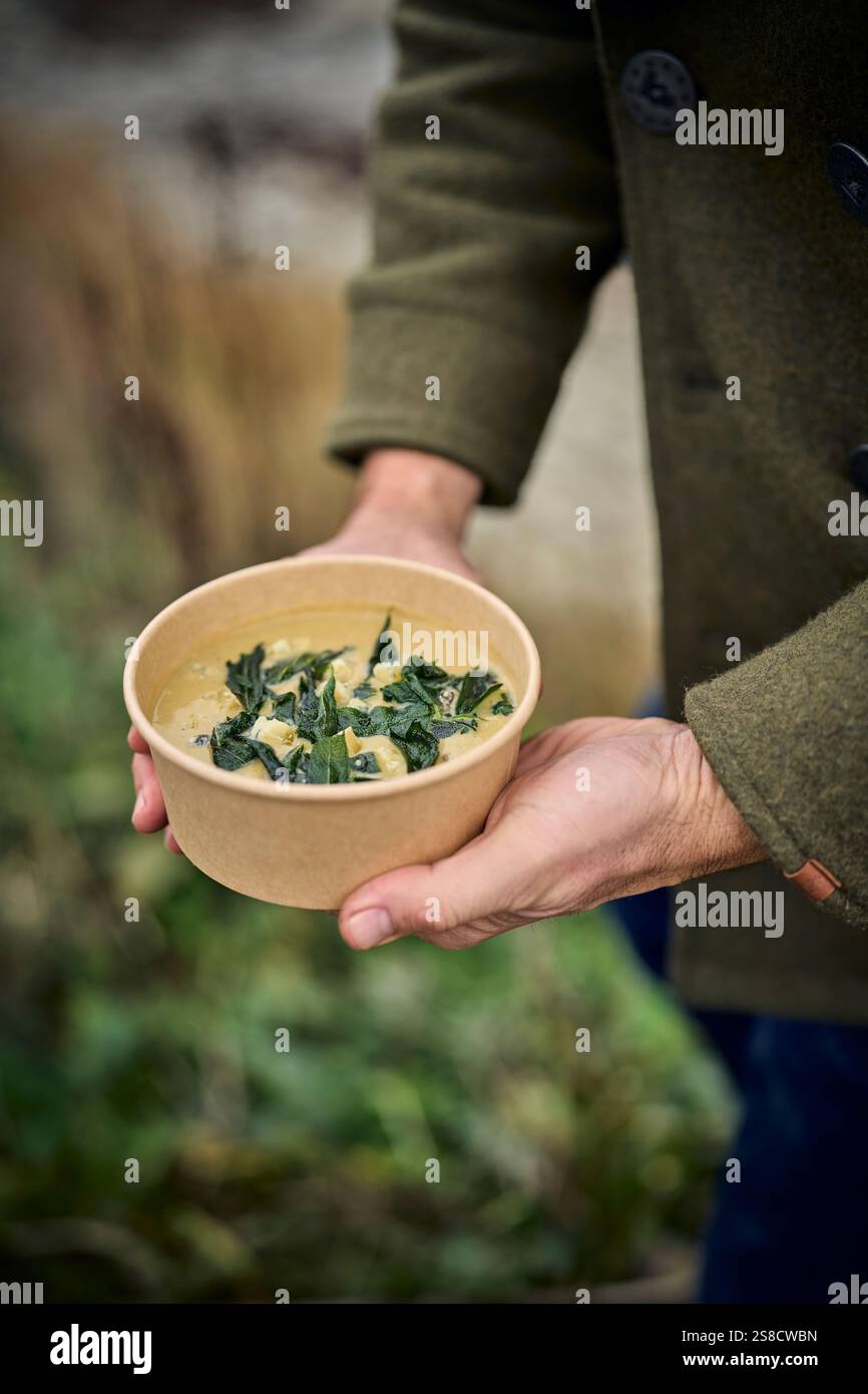 Winter celeriac and leek soup and flatbreads cooked over fire at the Hidden Hut cafe at Porthcurnick Beach, Cornwall, UK Stock Photo