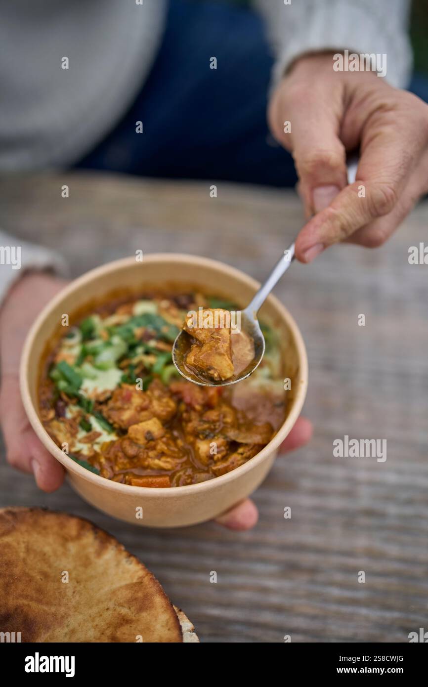 Winter spiced chicken soup and flatbreads cooked over fire at the Hidden Hut cafe at Porthcurnick Beach, Cornwall, UK Stock Photo