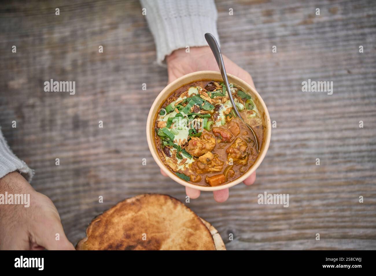 Winter spiced chicken soup and flatbreads cooked over fire at the Hidden Hut cafe at Porthcurnick Beach, Cornwall, UK Stock Photo