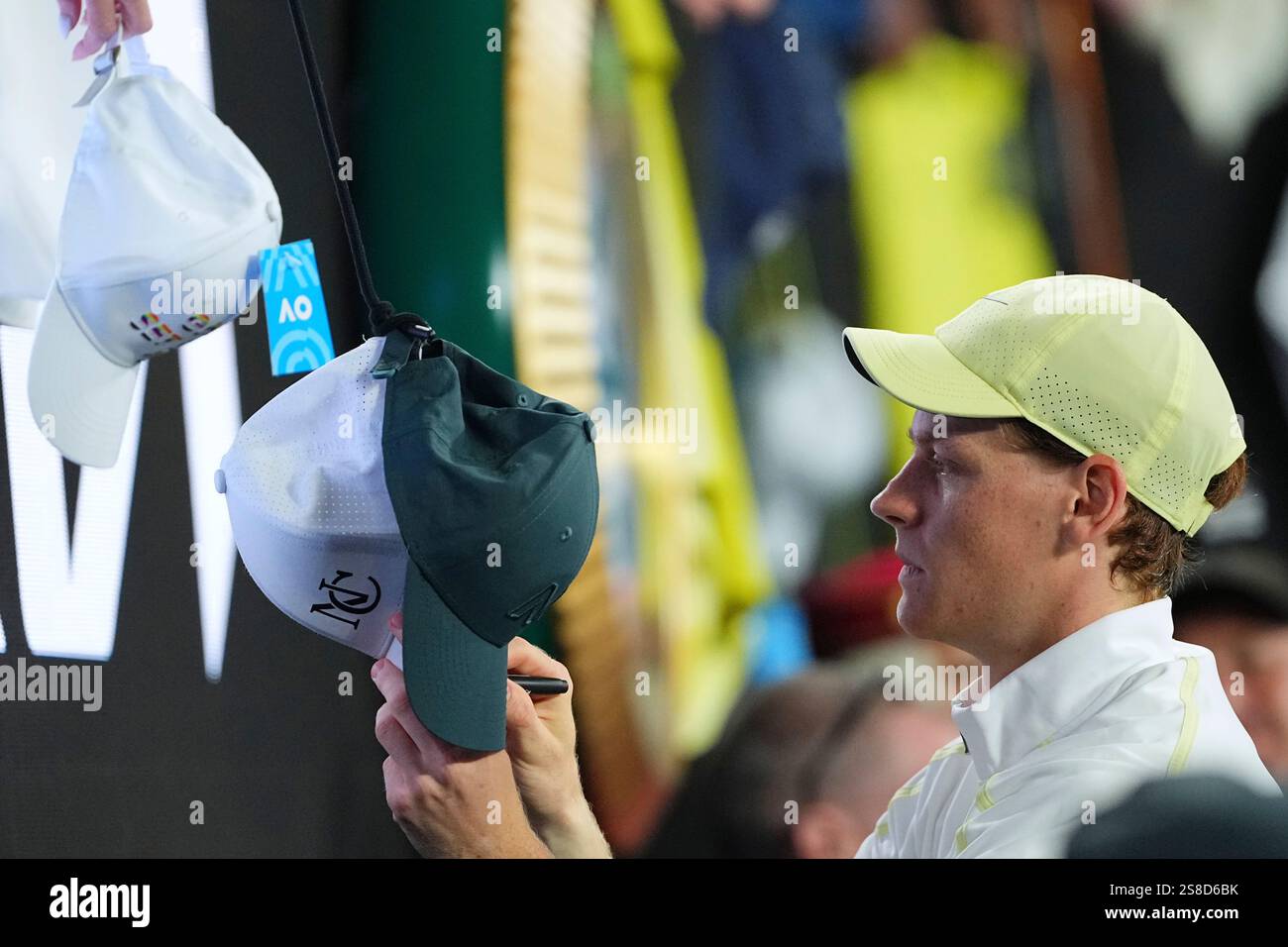 Jannik Sinner of Italy signs autographs after defeating Alex de Minaur