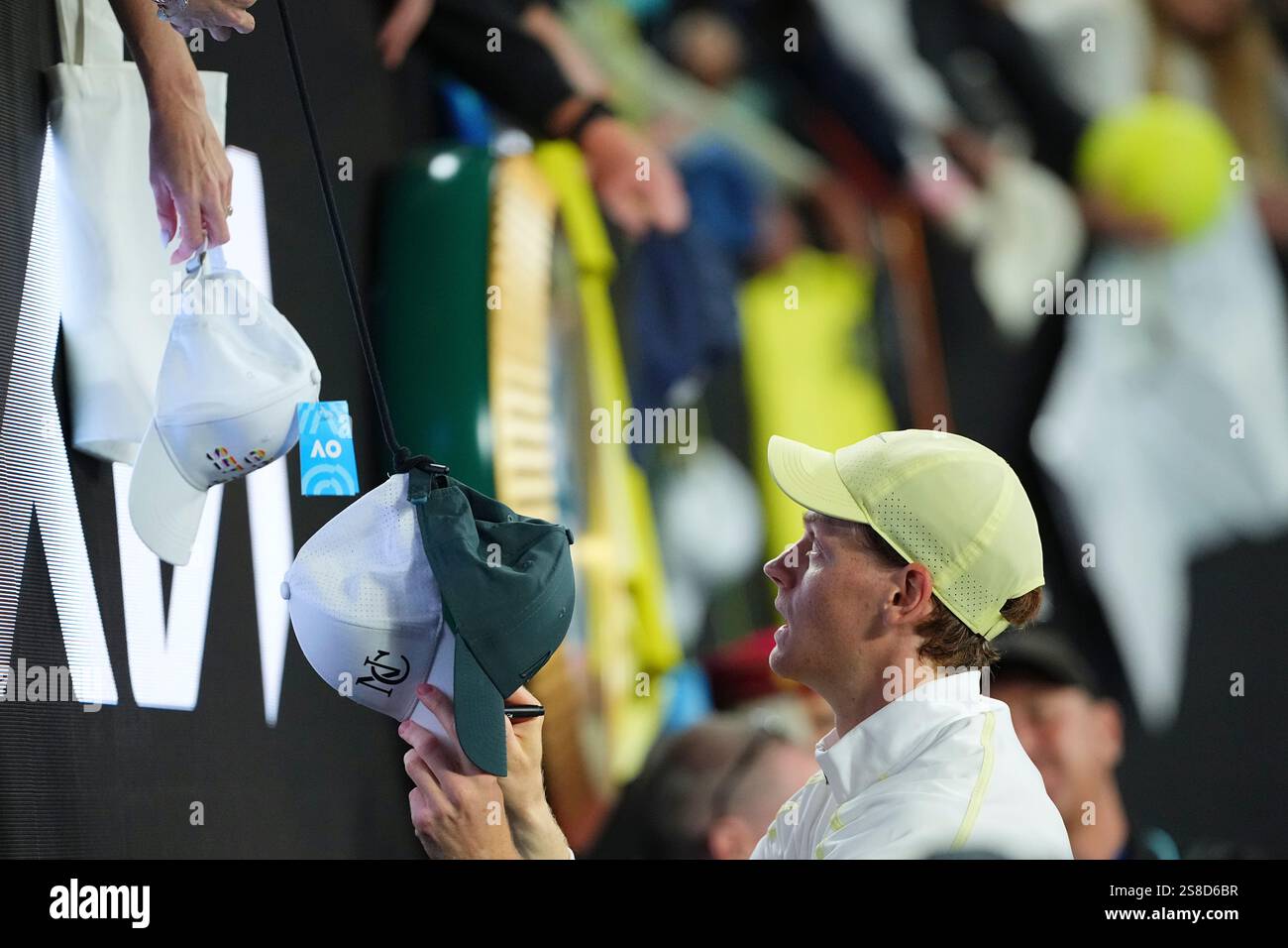 Jannik Sinner of Italy signs autographs after defeating Alex de Minaur