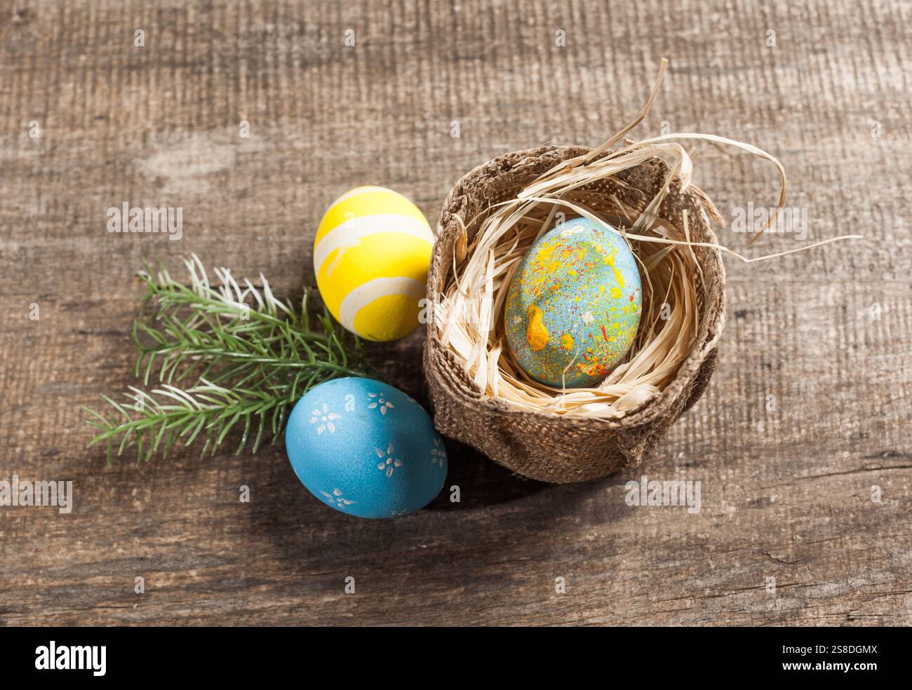 Easter eggs in nest on color wooden background Stock Photo - Alamy