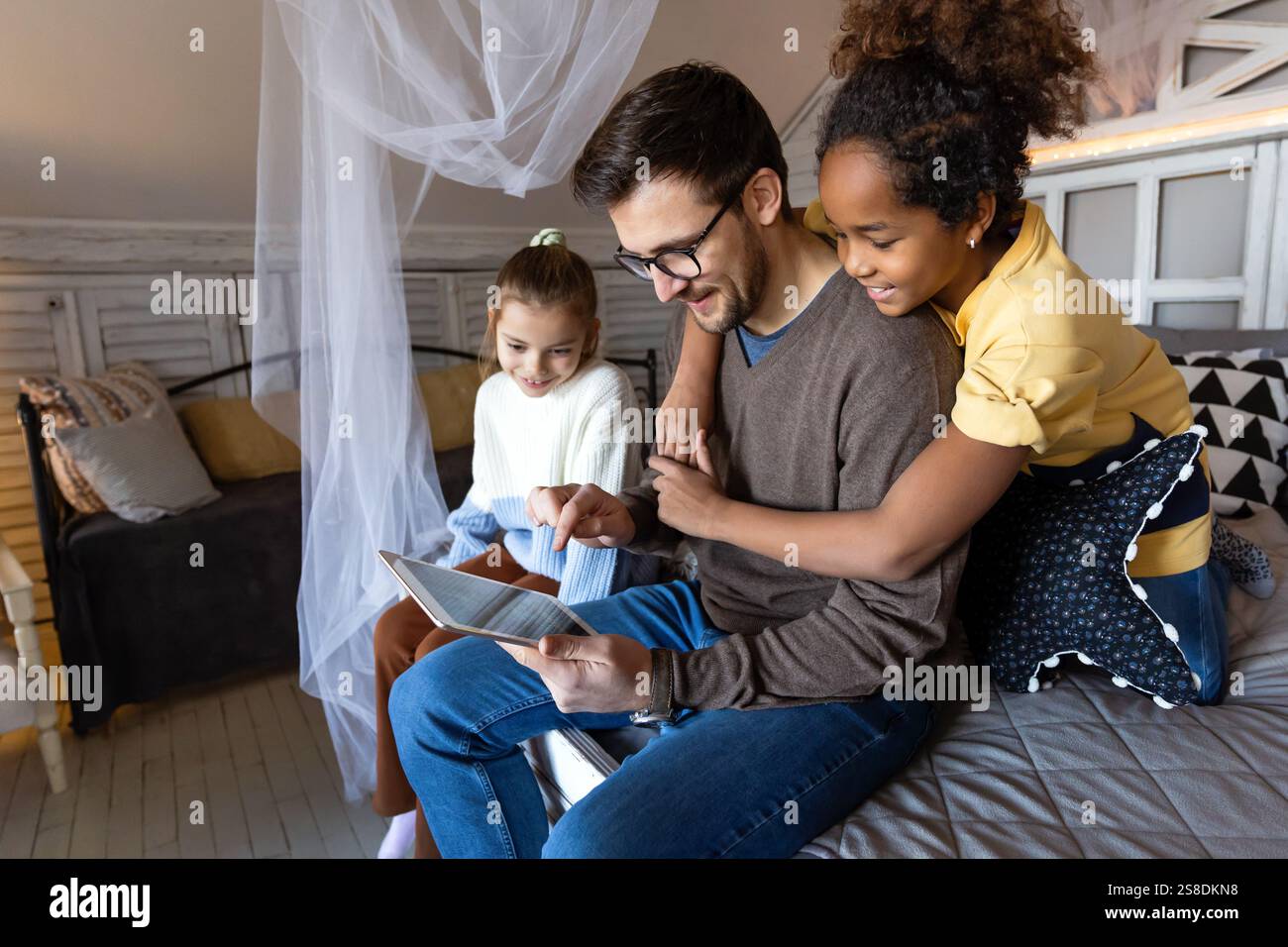 Happy diverse family resting at home on bed spending time together and ...