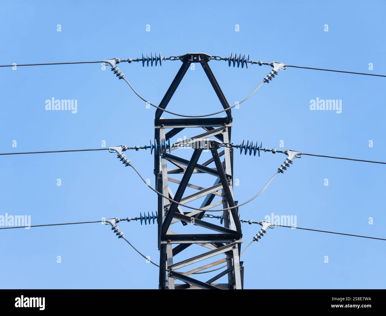 A close-up view of a high voltage electricity transmission tower and ...