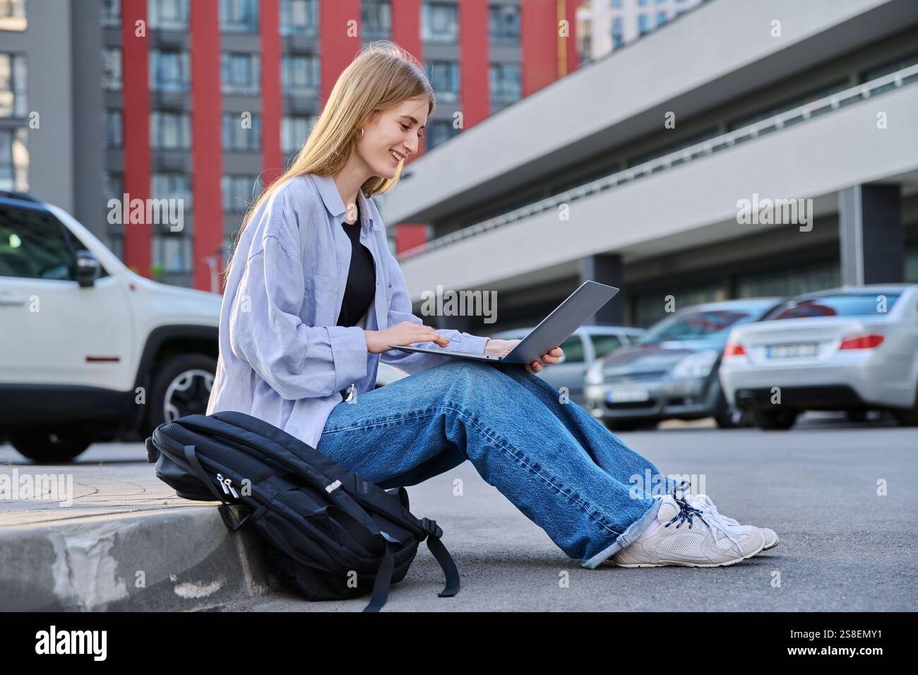 Young attractive serious female college student using, typing on laptop ...