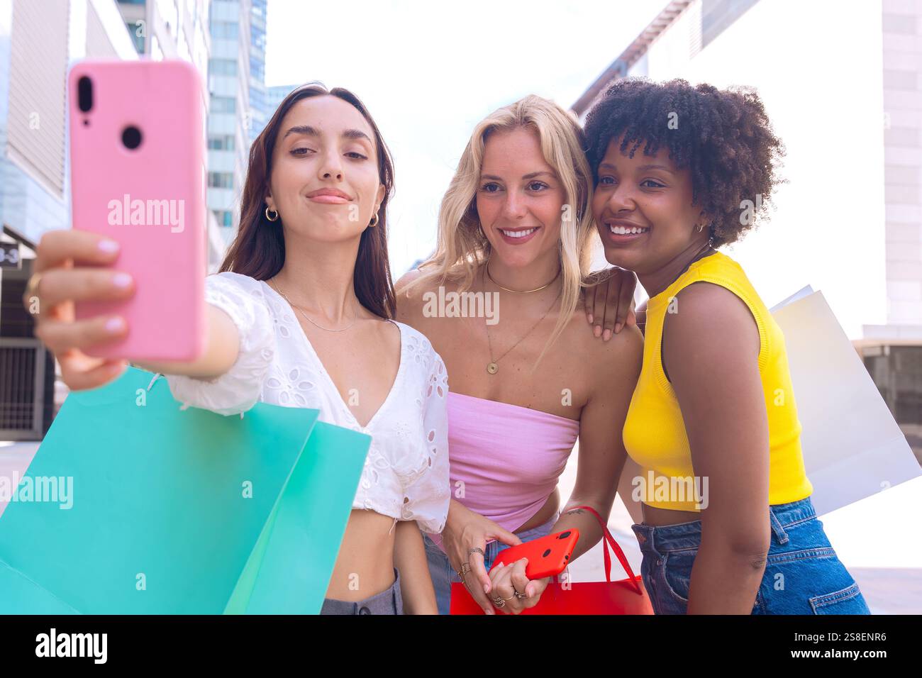 Three happy young women taking a selfie together in a city street Stock ...