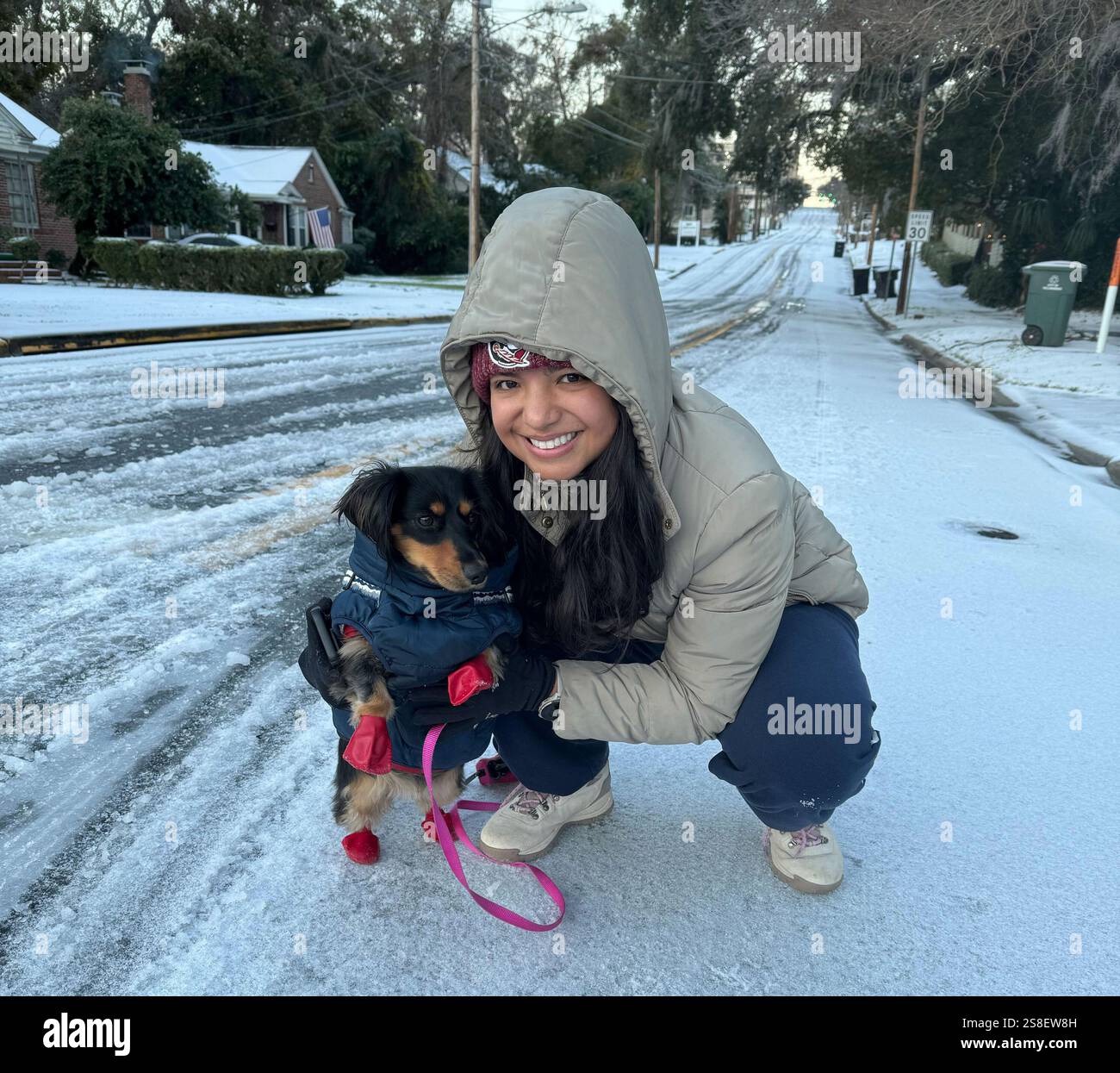 Lina Rojas prepares her dachshund Petunia with a warm vest and gloves