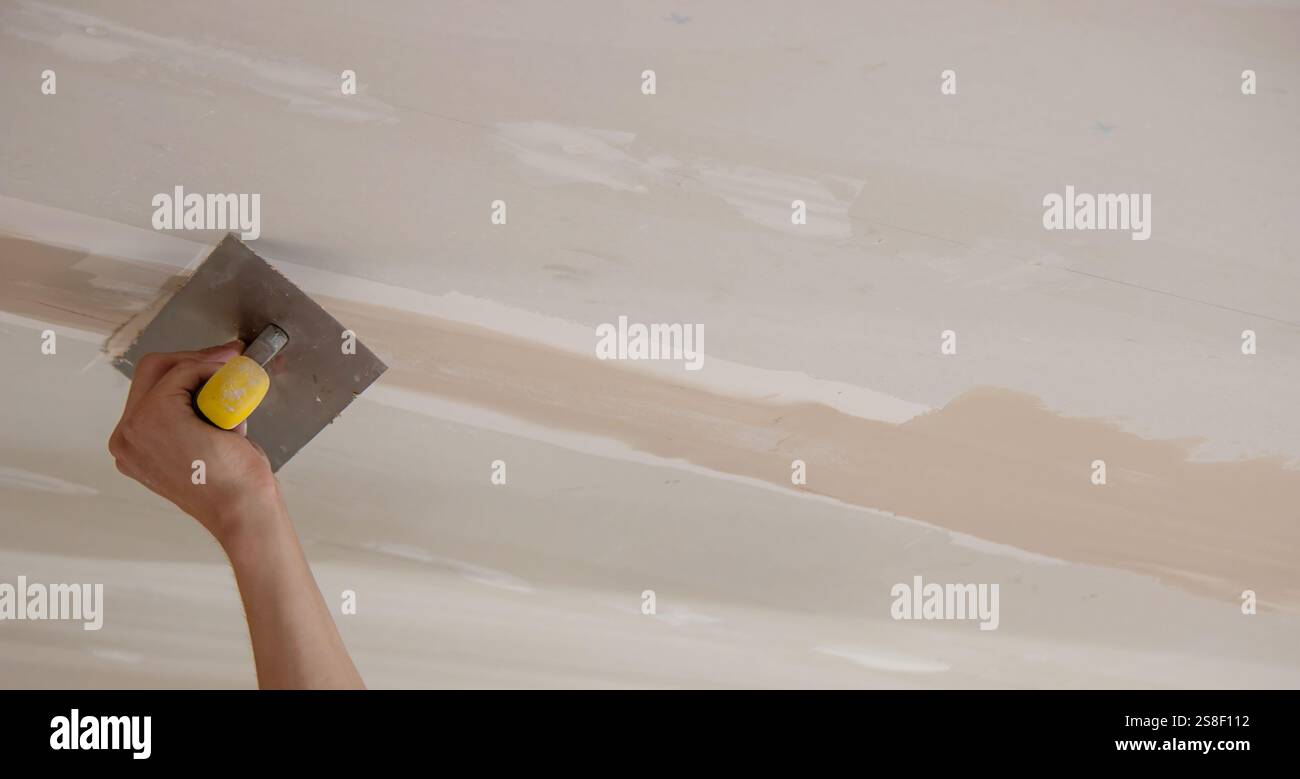 man plastering ceiling repair. Selective focus. Stock Photo