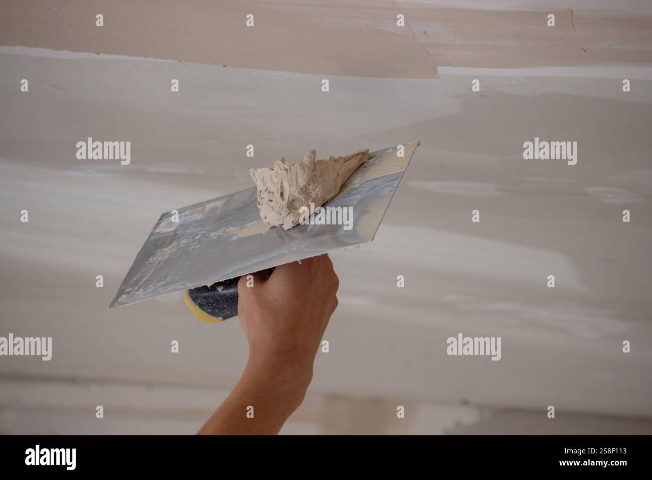 man plastering ceiling repair. Selective focus. Stock Photo