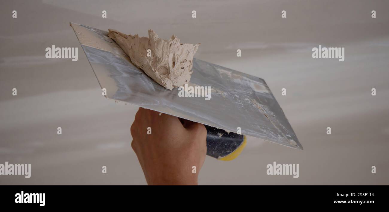 man plastering ceiling repair. Selective focus. Stock Photo