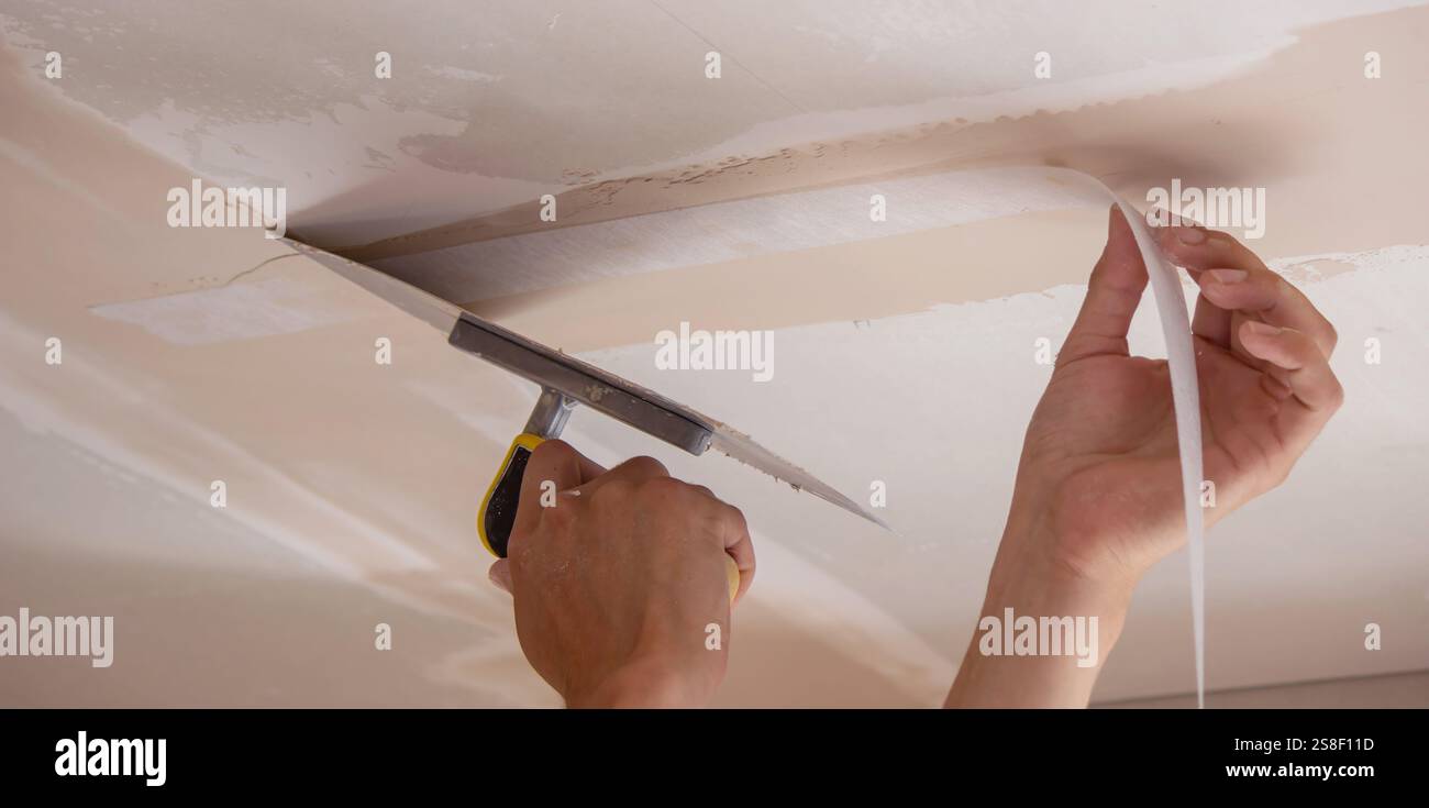 man plastering ceiling repair. Selective focus. Stock Photo